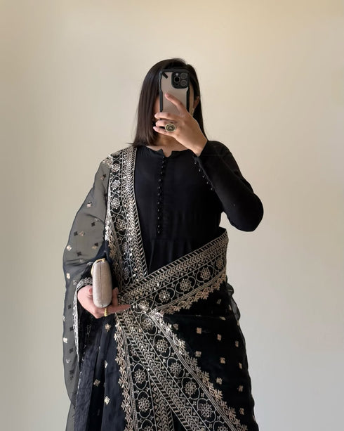 Stylish front view of Black Floral Cotton Suit with a Pure Fox Georgette kurta, intricate potli button work, sequin-embroidered dupatta, and flowy micro cotton palazzo.
